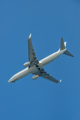 Passenger airplane. View exactly from below, silhouette against the blue sky.