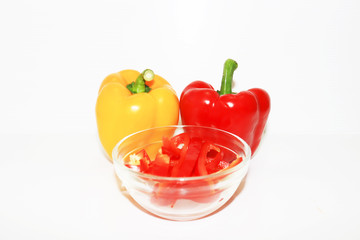 red pepper and yellow pepper in a bowl isolated on white background