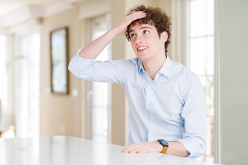 Young business man with curly read head smiling confident touching hair with hand up gesture,...