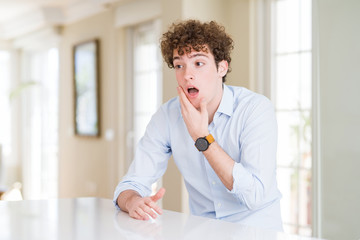 Fototapeta premium Young business man with curly read head Looking fascinated with disbelief, surprise and amazed expression with hands on chin