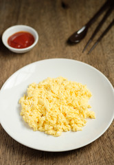 Scramble on a white plate with spoon and chopsticks,ketchup bowl