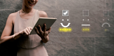 woman pressing face emoticon on virtual touch screen at smartphone .Customer service evaluation...