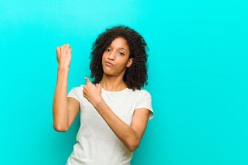 young black woman looking impatient and angry, pointing at watch, asking for punctuality, wants to...