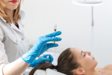 Close-up, the beautician makes injections of vitamins into the scalp for strengthening the hair.