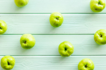 Green apples pattern on green wooden background top view