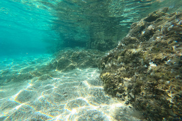 Fototapeta na wymiar Underwater rocks, sand and stones. The beautiful sandy and rocky bottom of the sea.