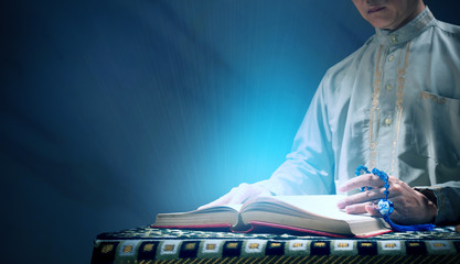 Quran or Kuran ( the islamic holy book) on black background with rosary bead ready to read