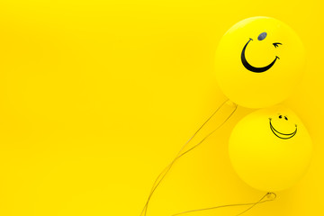 Happiness emotion. Yellow balloon with smile on yellow background top view space for text - obrazy, fototapety, plakaty