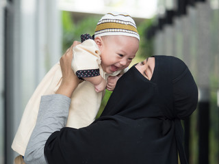 cute asian six-month asia baby in traditional muslim style dress