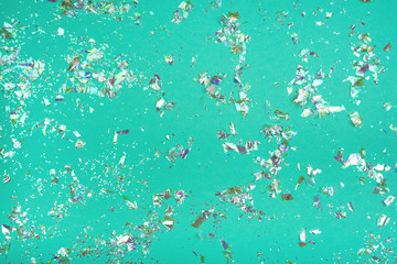 Neon confetti on green background. Holiday concept. Flat lay, top view.