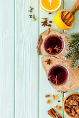 Mulled wine and fir branches frame on green wooden background top view copy space