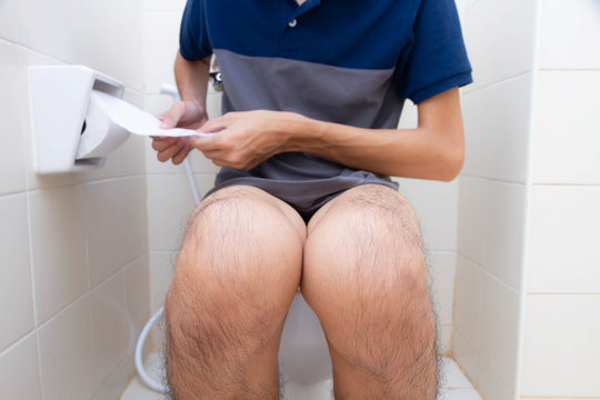 Man diarrhea sitting on toilet bowl