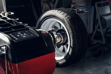 Part of broken car with wheel and tyre is waiting to be fixed.