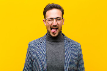 young handsome man with cheerful, carefree, rebellious attitude, joking and sticking tongue out,...