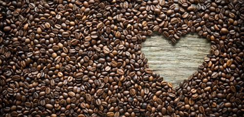 Coffee beans in heart shape on rustic wooden