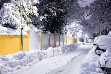 Quiet street in the winter evening, houses and cars covered with snow. City after snowfall....
