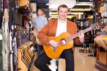 Boy and father choosing acoustic guitar