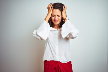 Young beautiful woman wearing t-shirt standing over white isolated background suffering from...