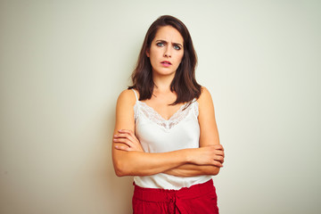 Obraz premium Young beautiful woman wearing t-shirt standing over white isolated background skeptic and nervous, disapproving expression on face with crossed arms. Negative person.