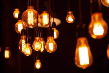 classic different retro light bulbs hanging on brick wall background at night