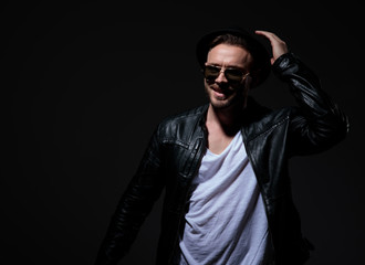 Fototapeta premium happy cool guy wearing leather jacket on grey background