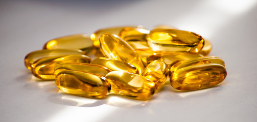Close up of food supplement oil filled capsules suitable for: fish oil, omega 3, omega 6, omega 9, evening primrose, borage oil, flax seeds oil, vitamin A, vitamin D, vitamin D3, vitamin E.