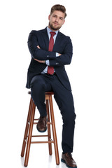 confident young businessman folding arms on white background