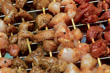 number of skewers with slices of meat sauce spicy flavored base culinary cooking barbecue