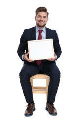 happy young businessman holding white board in studio