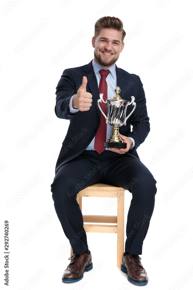 Wall mural happy young businessman holding trophy