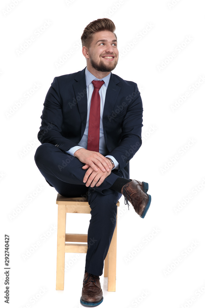 Wall mural enthusiastic businessman sitting on wooden chair and looking up