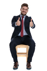 enthusiastic young businessman making thumbs up sign