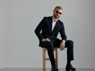 businessman sitting and resting hands while looking at camera serious