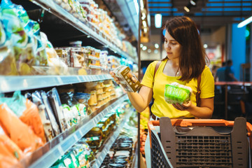 young pretty adult woman do shopping in grocery store