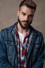 Fototapeta premium young fashion man wearing blue denim jacket on brown background