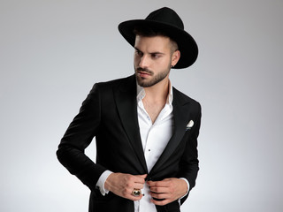 attractive young model arranging coat and looking to side
