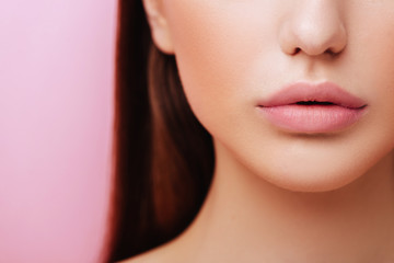 Lips of Beauty cute fashion model with natural make up on pink background