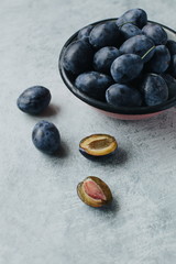 harvest of ripe blue plums on a table on a light background