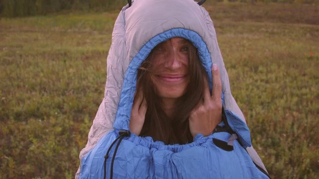 Close-up face of a caucasian woman in a sleeping bag in the mountains. Recorded in Raw on Blackmagic camera.