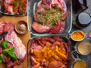 Raw meat background. with a variety of herbs and spices. On the grey concrete table.