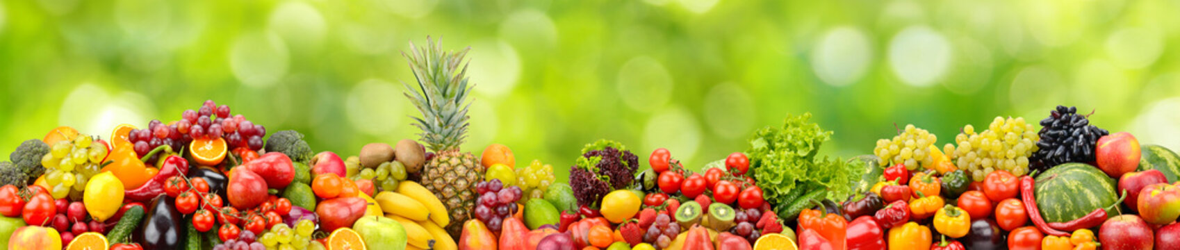 Various useful fruits and vegetables on green background.