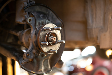 Close up of Old Brake Disc of the vehicle for repair.Automobile mechanic in process of new tire replacement.Car brake repairing in garage.Car Service and technician concept.