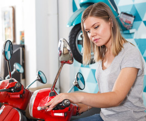 Obraz na płótnie Canvas Young female is choosing modern motobikes