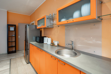 Modern interior of spacious light studio apartment. Stylish kitchen set.