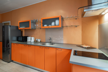 Modern interior of spacious light studio apartment. Stylish kitchen set.