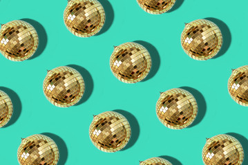 New year baubles. Shiny gold disco balls on mint background. Pop disco style attributes, retro concept. Creative Christmas pattern. Flat lay, top view.