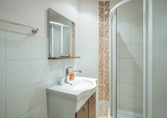 Modern simple interior of bathroom. Shower cabin. White sink. Filtered.