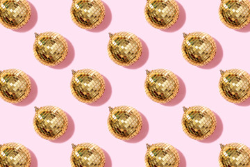 Creative Christmas pattern. Shiny gold disco balls over pink background. Flat lay, top view. New...