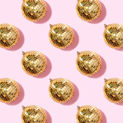 New year baubles. Shiny gold disco balls on pink background. Pop disco style attributes, retro concept. Creative Christmas pattern. Flat lay, top view.