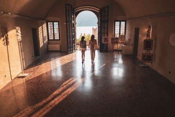 Junge Frauen gehen durch Torbogen in Malcesine am Gardasee, Italien
